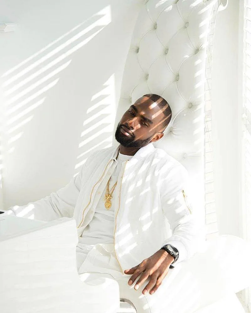 Chad Focus seated beside a white piano