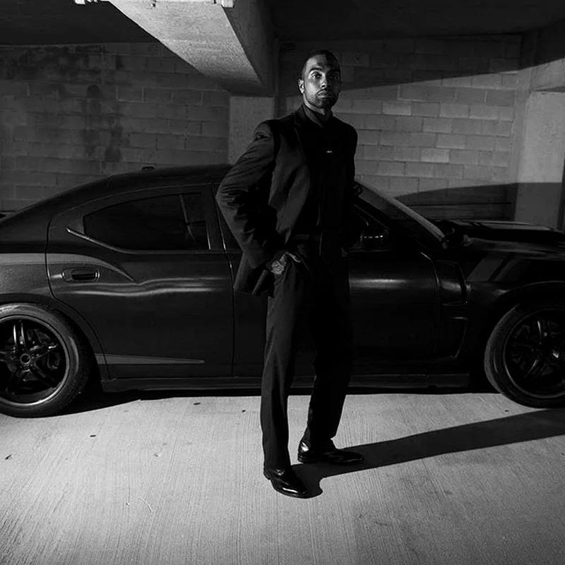 Chad Focus in a formal portrait beside a car